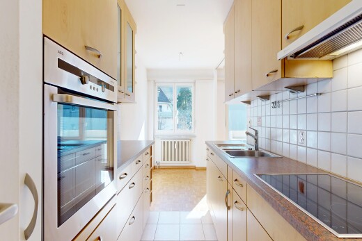 kitchen featuring oven, black electric cooktop, radiator, tasteful backsplash, and glass insert cabinets