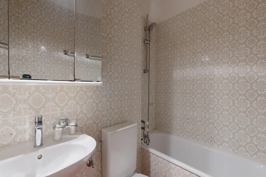 salle de bains avec miroir, évier, douche-bain combinés, toilette, et inside property