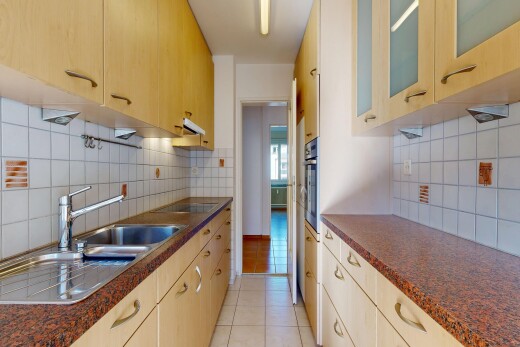 cuisine avec plans de travail, dark countertops, armoires avec insert en verre, glass insert cabinets, et dosseret