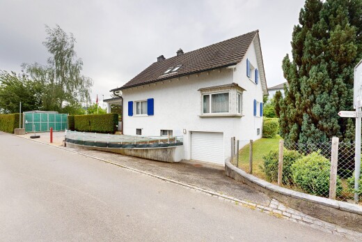 außenansicht mit property visible, zaun, eingebaute garage, overcast, und stuckverkleidung