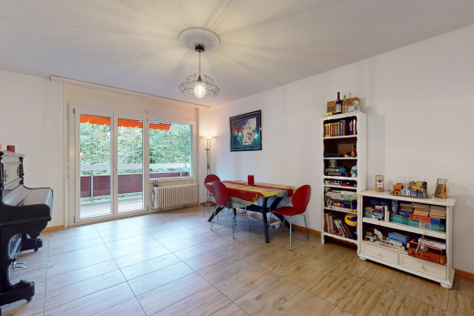 gefliestes wohnzimmer mit viel tageslicht und heizkörper