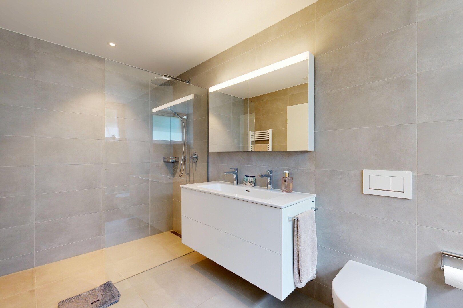 bathroom featuring a towel warming rack, tile walls, a walk in shower, vanity, and radiator heating unit