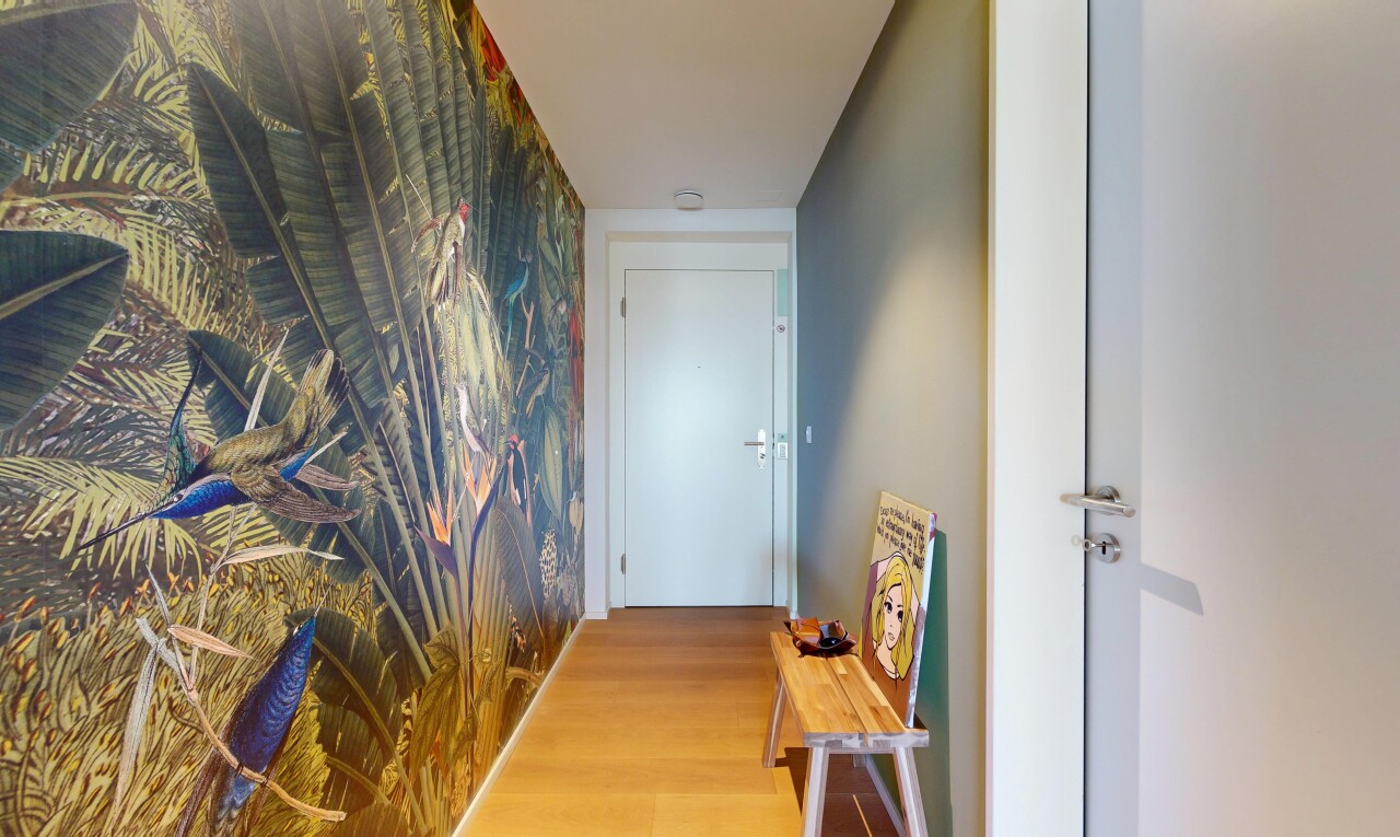 hallway featuring an accent wall, wallpapered walls, and wood finished floors
