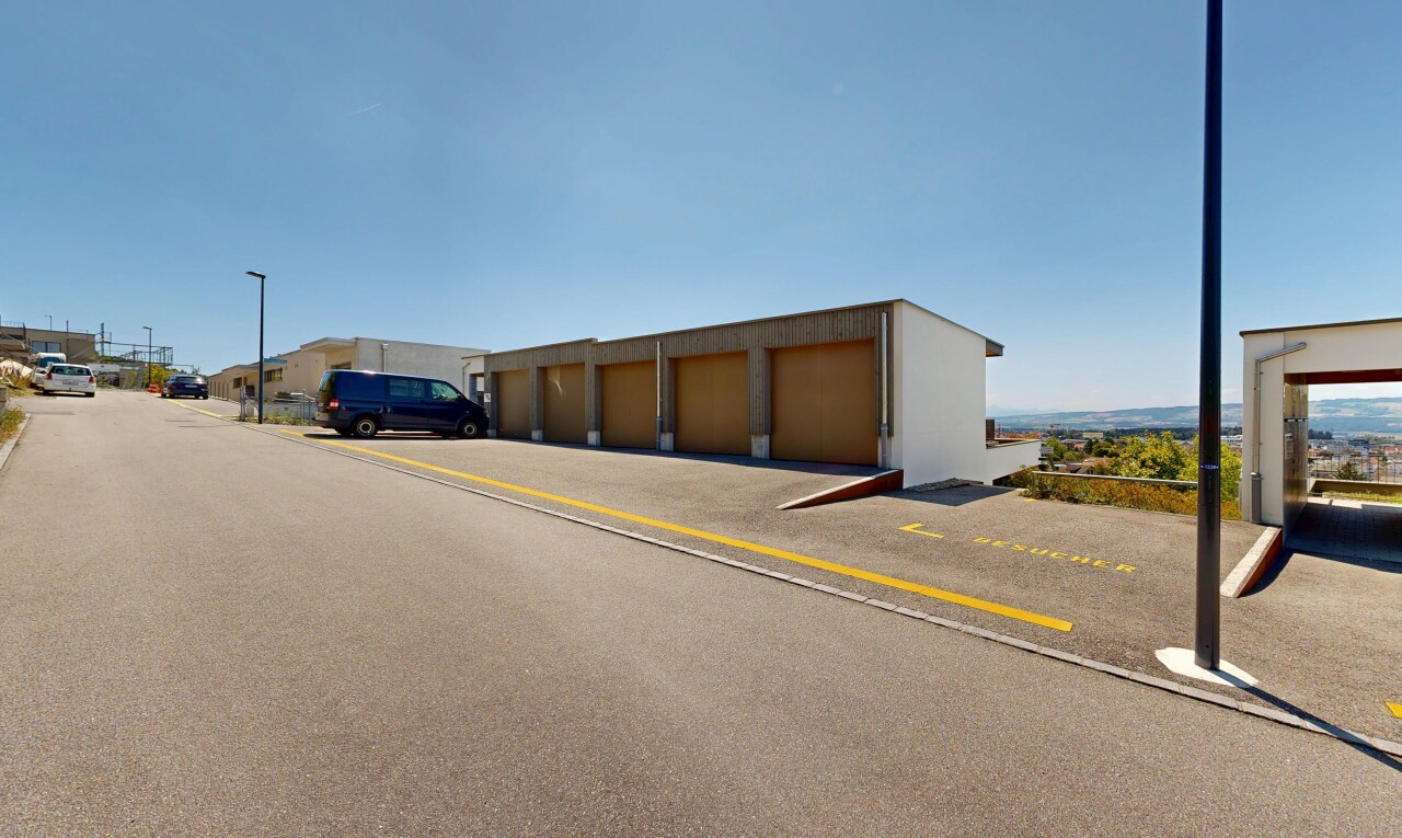 view of building exterior with community garages and street lighting
