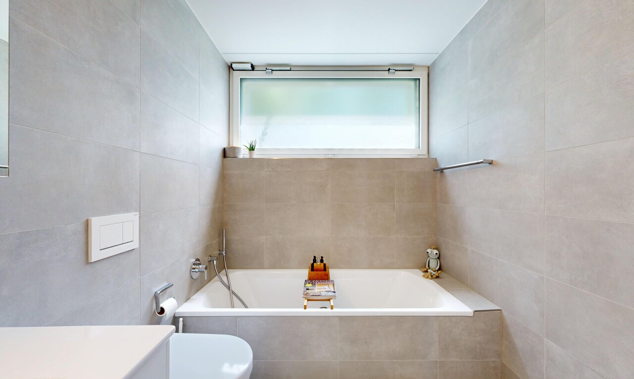 bathroom with tile walls, a bath, and vanity