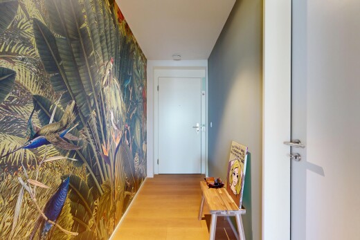 hallway featuring an accent wall, wallpapered walls, and wood finished floors