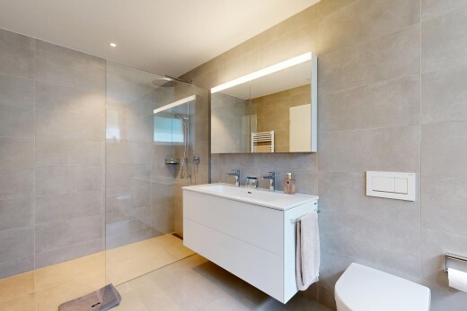 bathroom featuring a towel warming rack, tile walls, a walk in shower, vanity, and radiator heating unit
