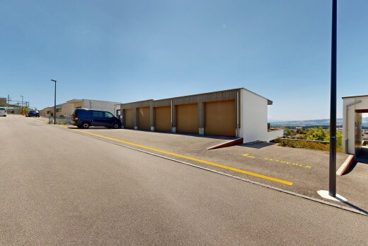 view of building exterior with community garages and street lighting