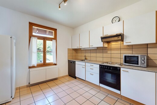 kitchen featuring backsplash, light countertops, black appliances, and white cabinets