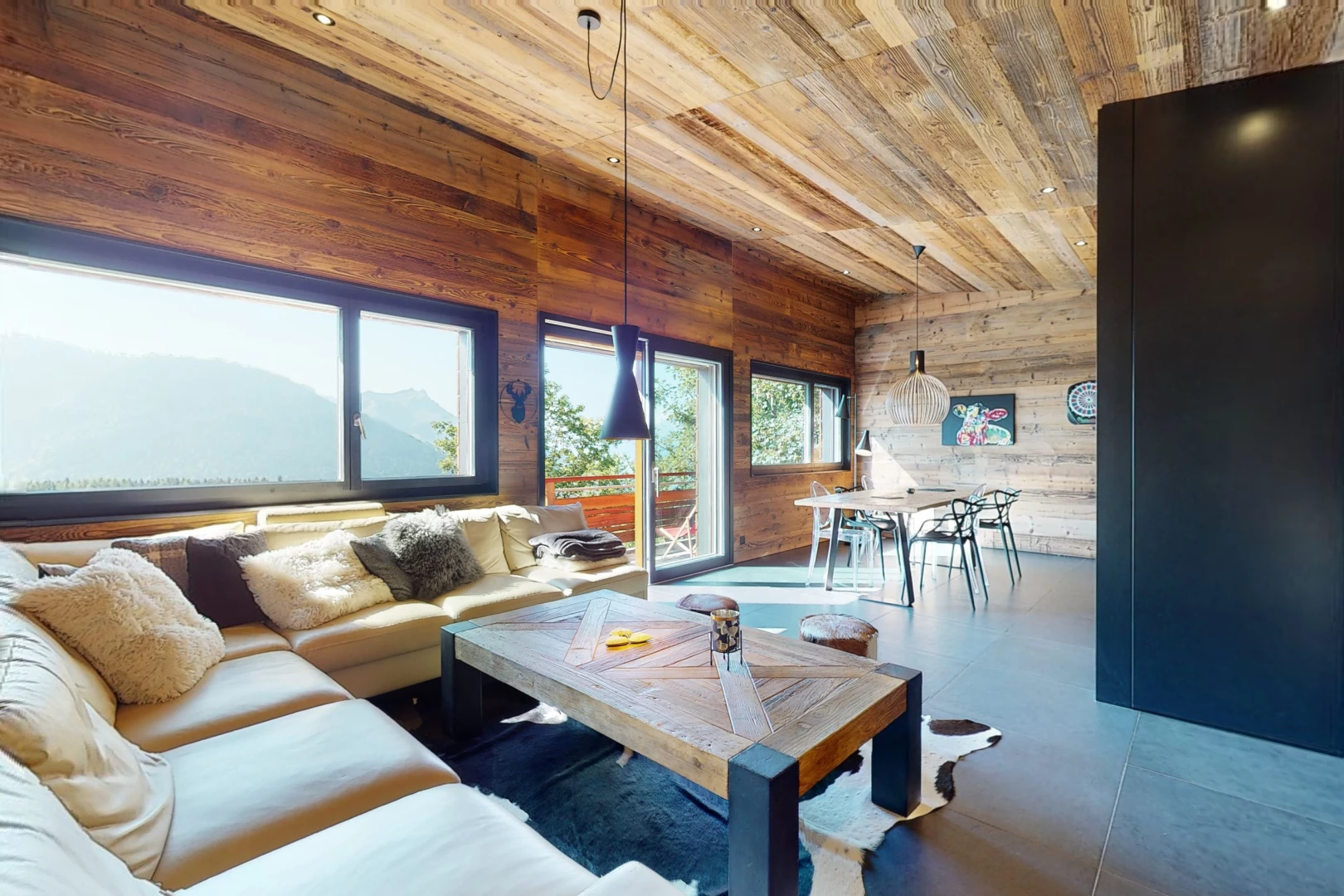 salon / salle à manger avec lumière naturelle, plafond de bois, et mur en bois