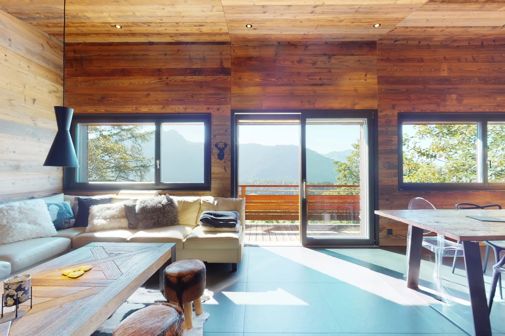 salon avec plafond voûté, carrelage, lumière naturelle, plafond de bois, et mur en bois
