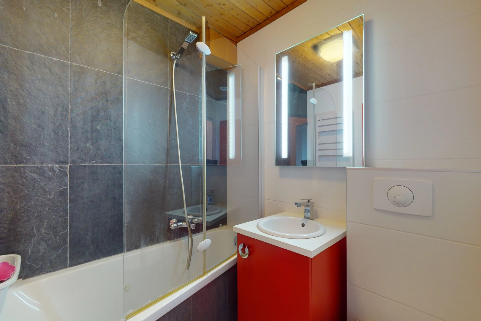 salle de bain avec meuble-lavabo, miroir, vasque, lumière naturelle, bain-douche, et plafond de bois