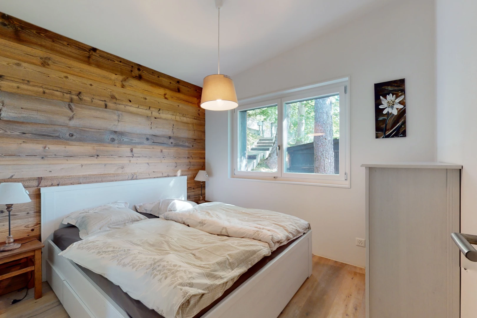 chambre avec plancher de bois, mur en bois, et lumière naturelle