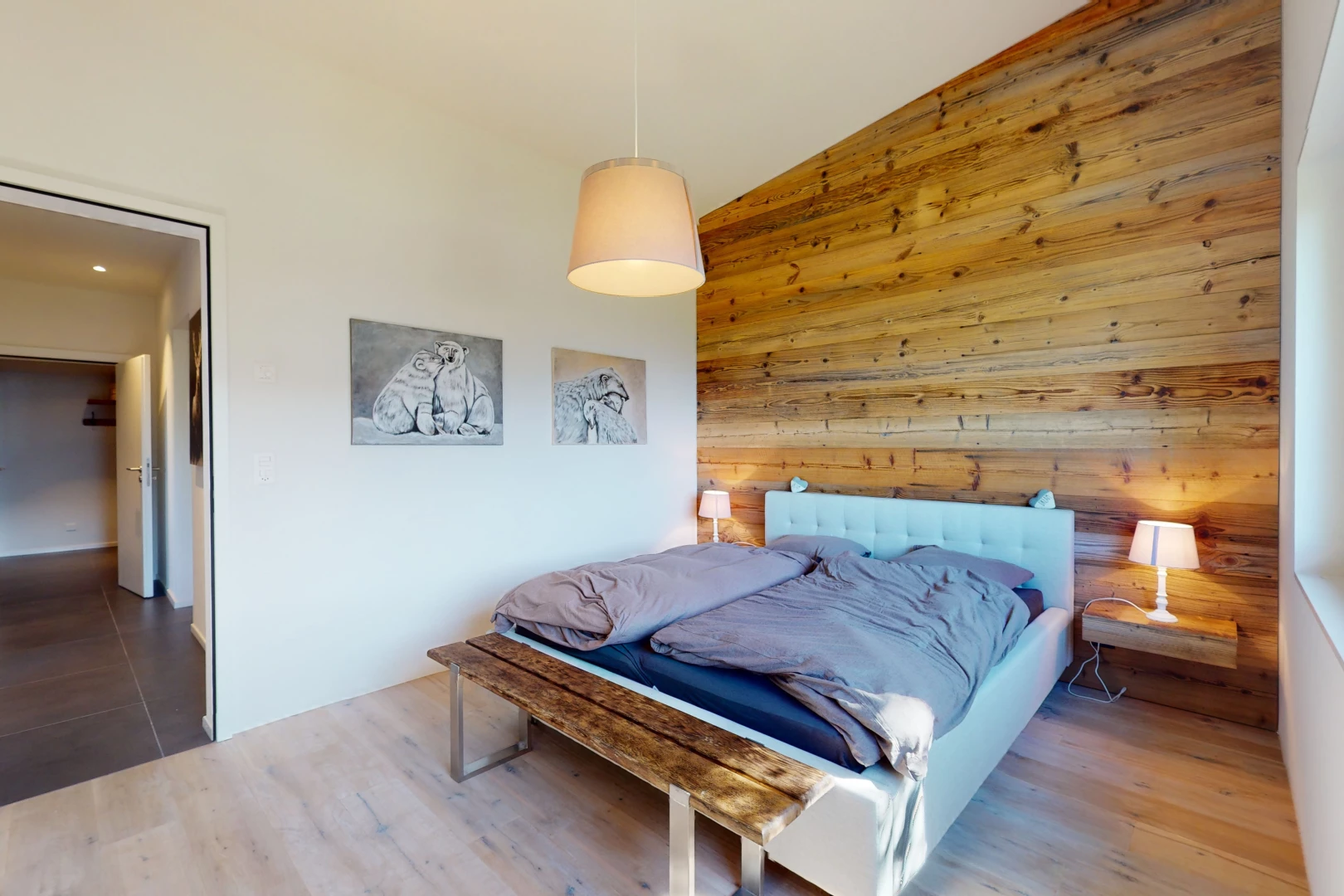 chambre avec plancher de bois, plafond voûté, mur en bois, et carrelage