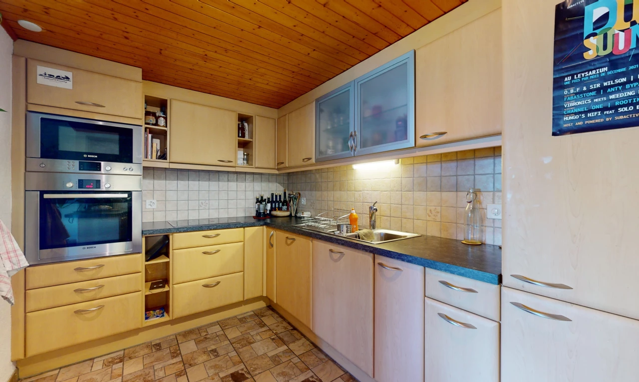 cuisine avec dosseret, four, carrelage, plan de travail, micro-ondes, et plafond de bois
