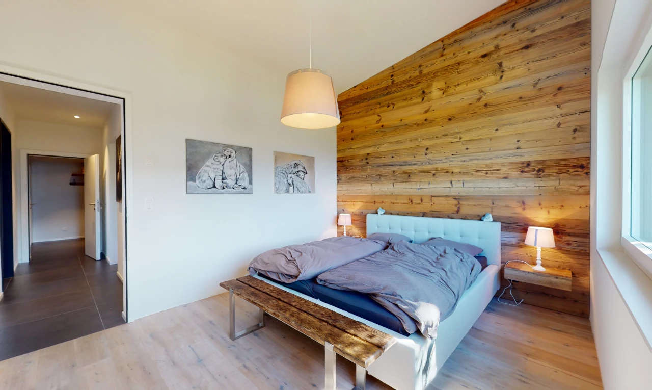 chambre avec plancher de bois, plafond voûté, mur en bois, et carrelage