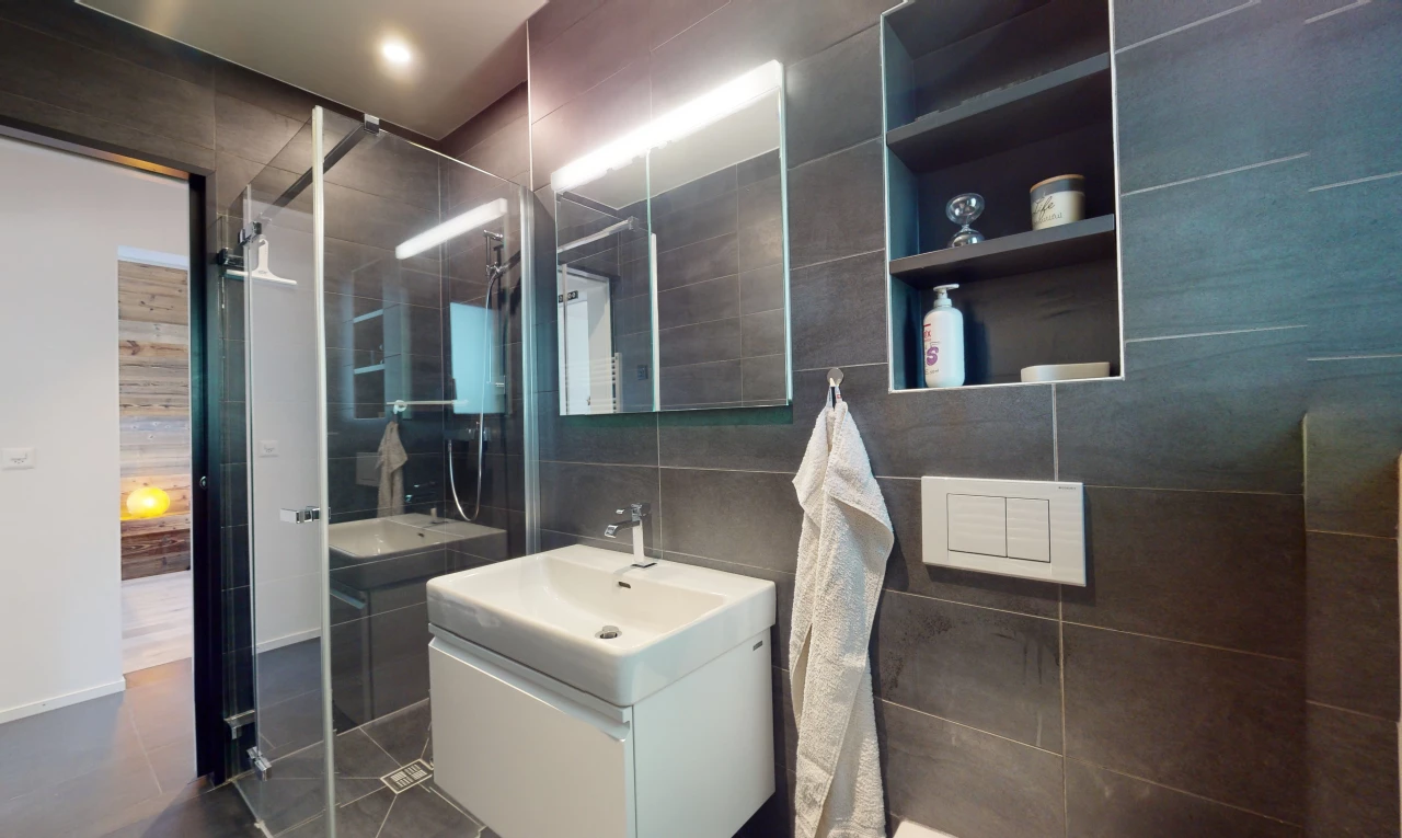 salle de bain avec carrelage, vasque, miroir, mur carrelé, meuble-lavabo, et douche