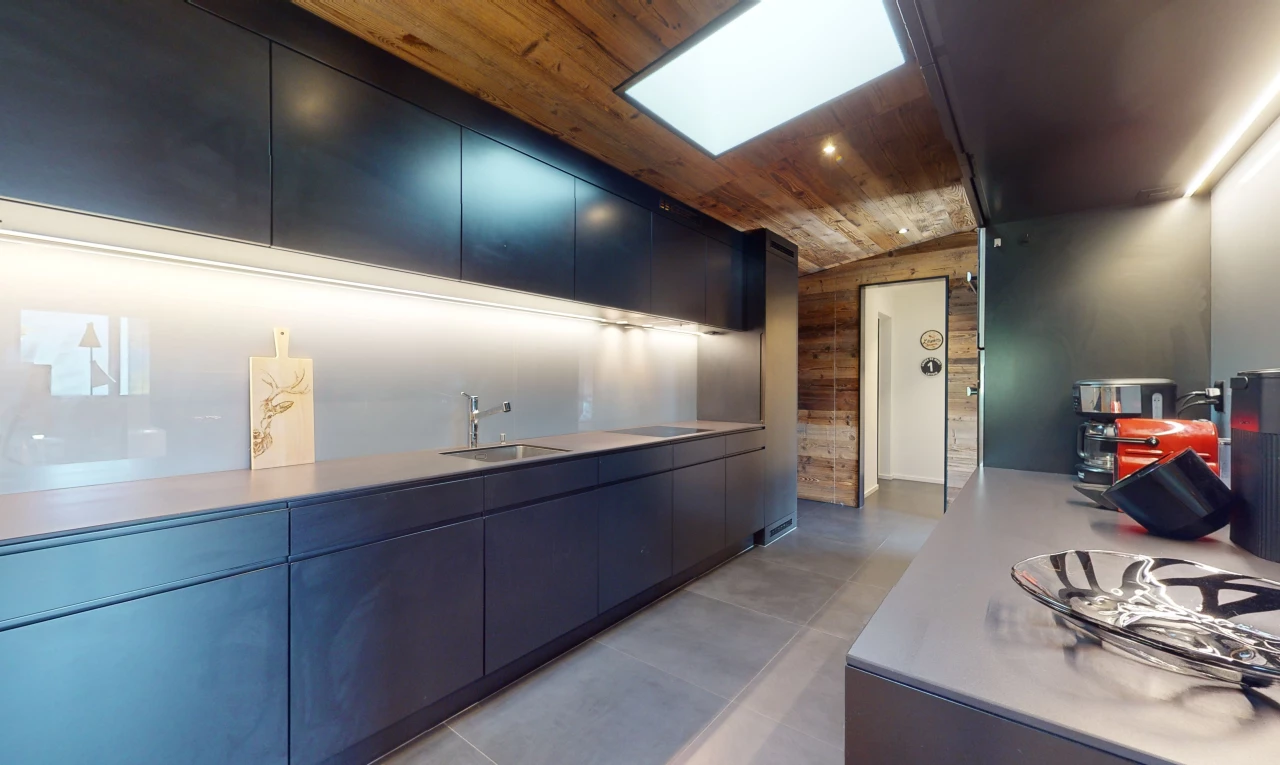 cuisine avec plafond voûté, carrelage, meubles marron foncé, plan de travail, plafond de bois, et lucarne