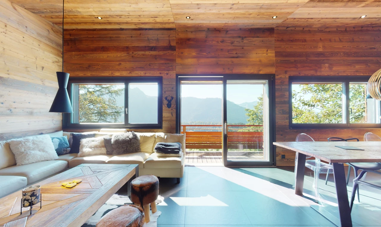 salon avec plafond voûté, carrelage, lumière naturelle, plafond de bois, et mur en bois