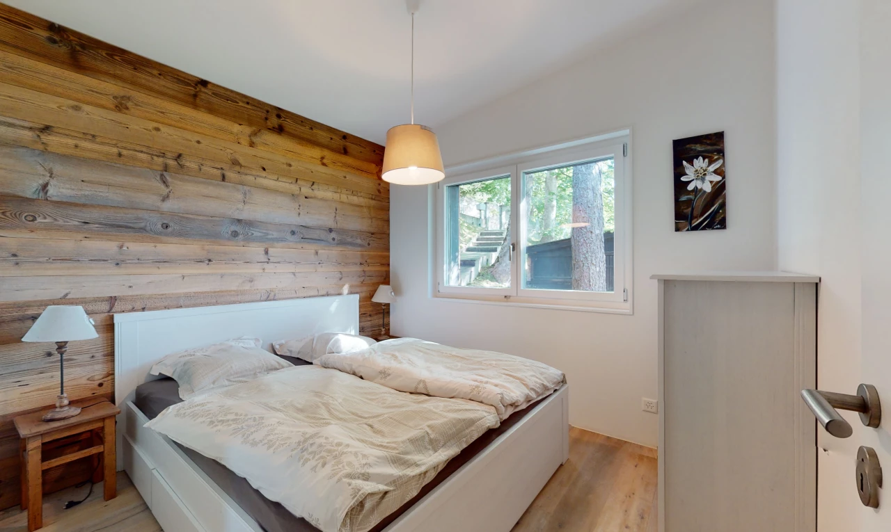 chambre avec plancher de bois, mur en bois, et lumière naturelle