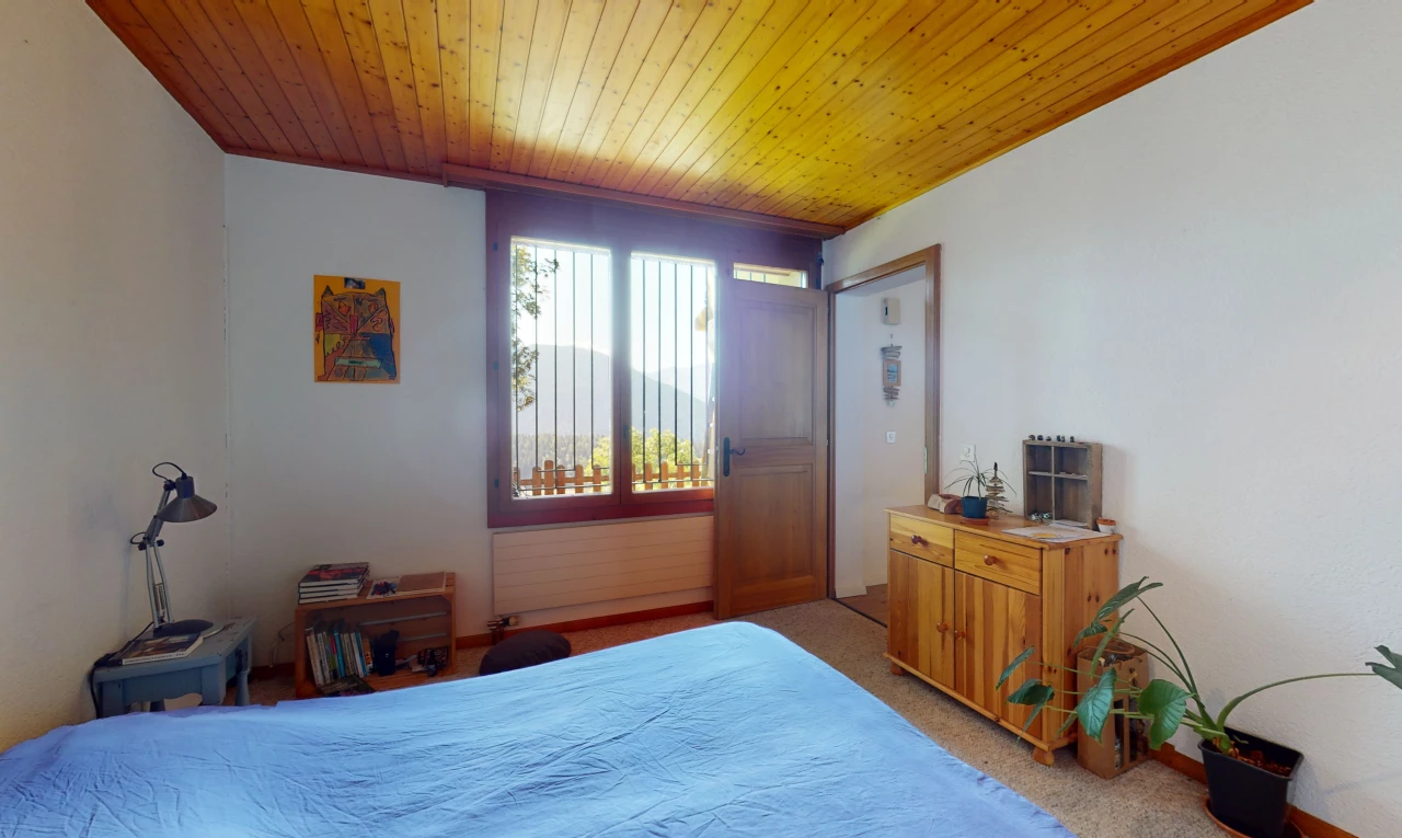 chambre avec moquette, lumière naturelle, et plafond de bois