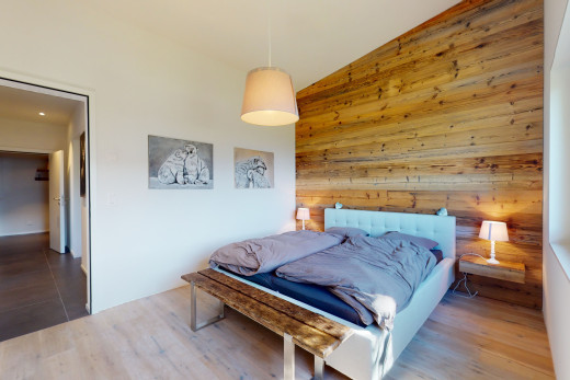 chambre avec plancher de bois, plafond voûté, mur en bois, et carrelage