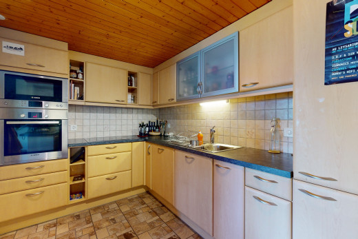 cuisine avec dosseret, four, carrelage, plan de travail, micro-ondes, et plafond de bois