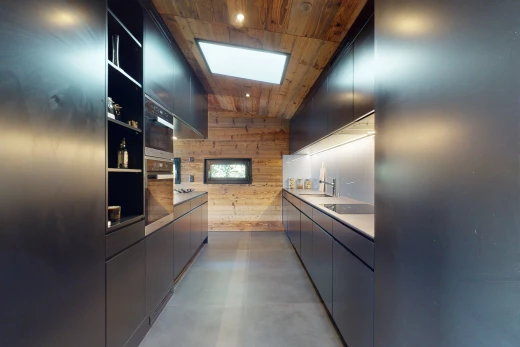 cuisine avec plafond en béton, lucarne, mur en bois, et plafond de bois
