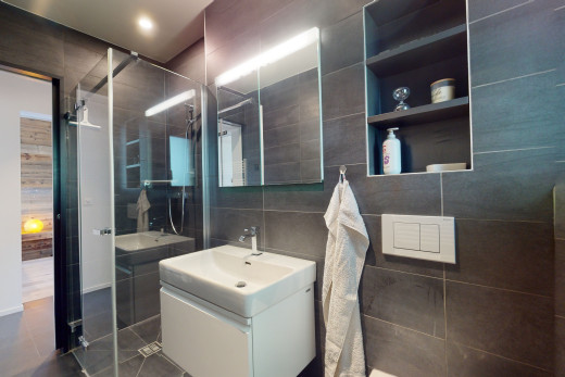 salle de bain avec carrelage, vasque, miroir, mur carrelé, meuble-lavabo, et douche