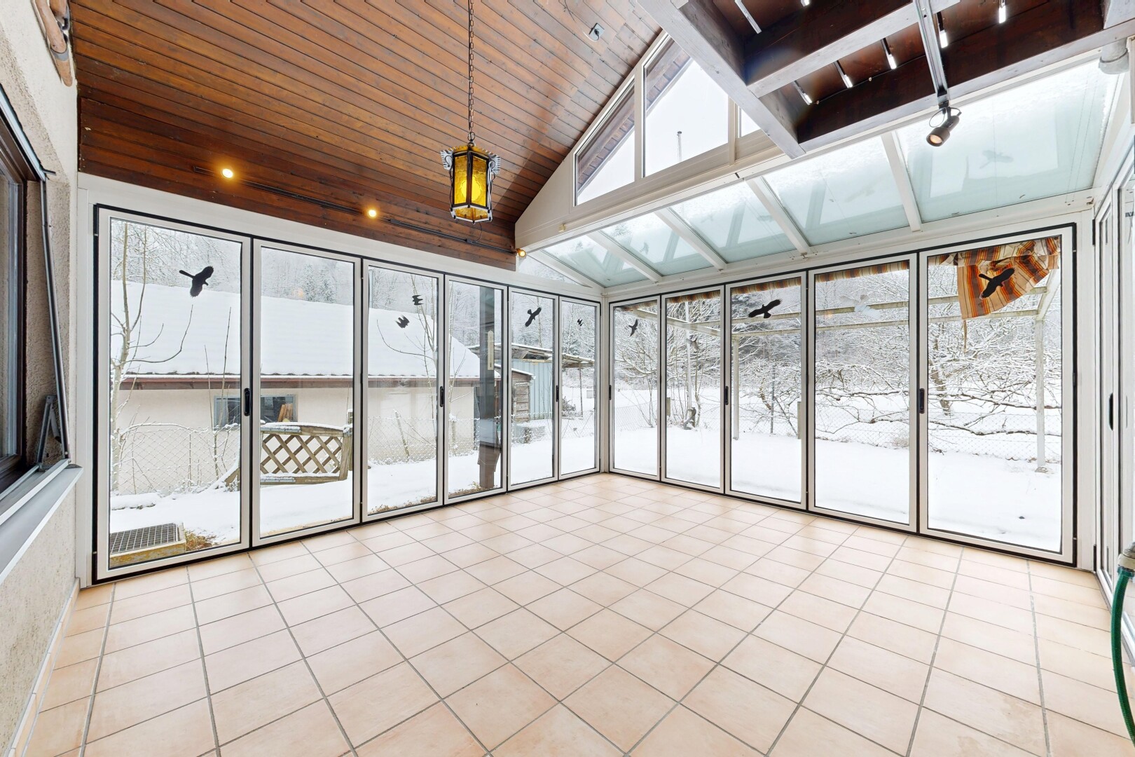 unfurnished room with lofted ceiling, wood ceiling, light tile patterned floors, and expansive windows