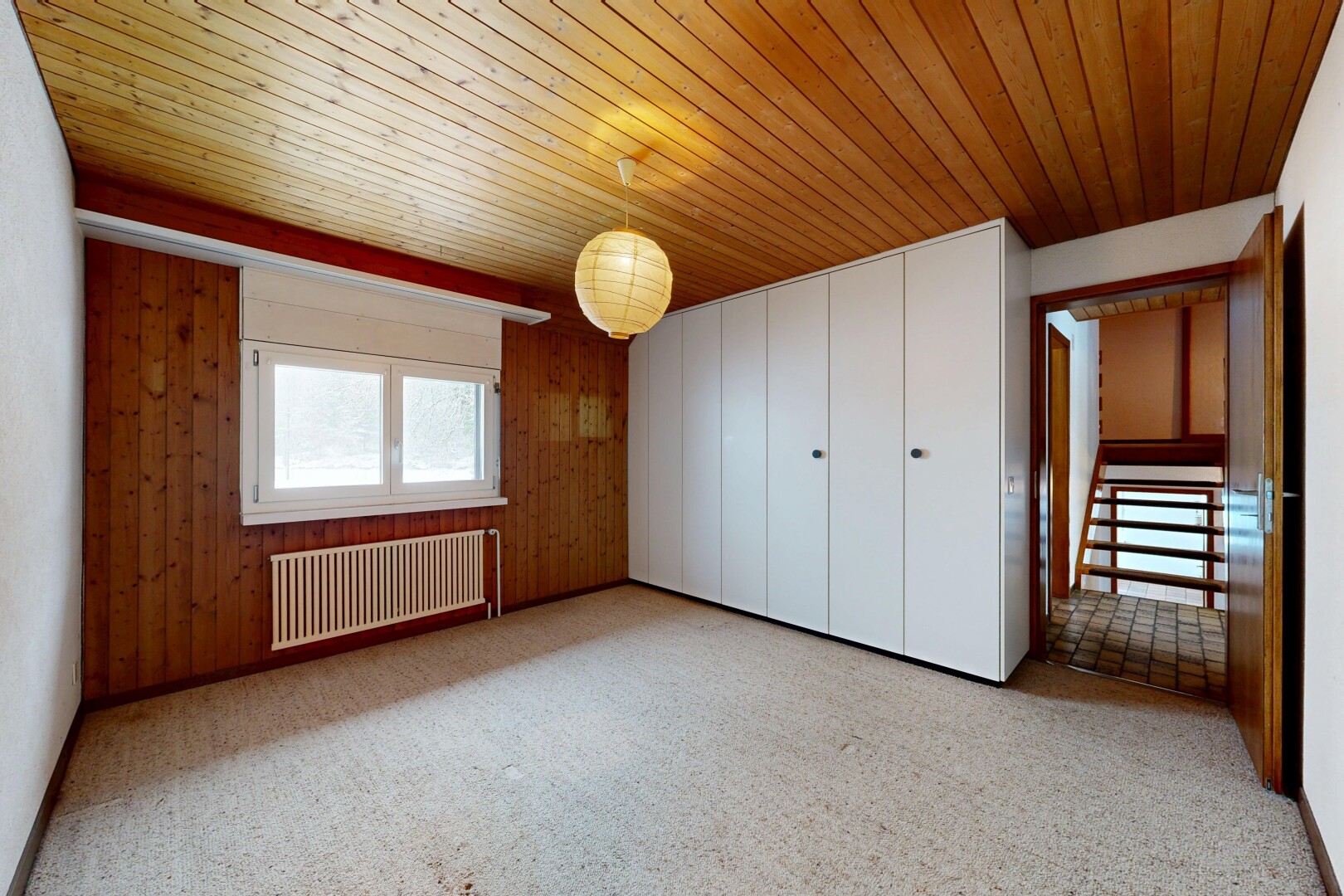 unfurnished room with radiator, wooden walls, and wood ceiling