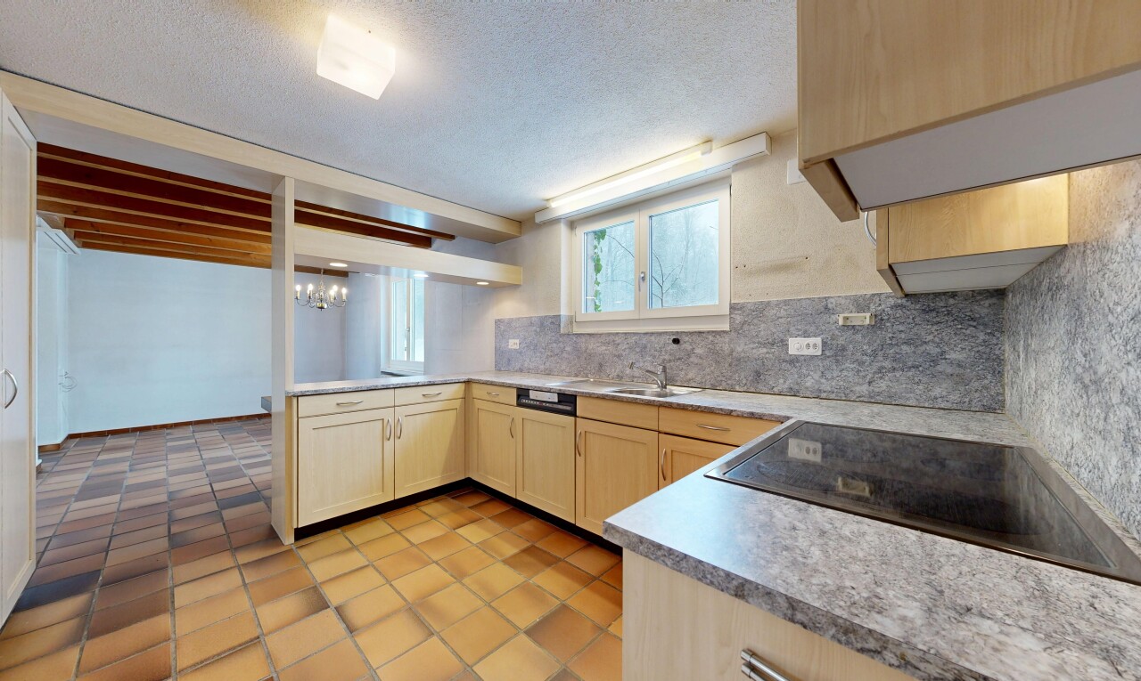 kitchen with light brown cabinetry, light countertops, black electric stovetop, a textured ceiling, and tasteful backsplash