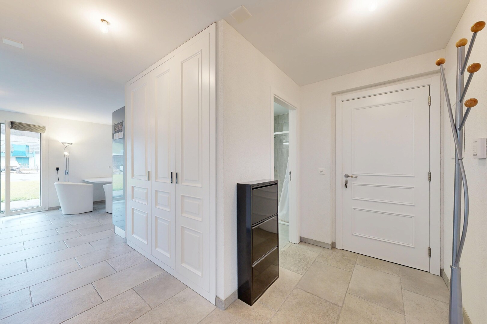 couloir avec inside property, cloison sèche, drywall, sol en carrelage, et tile floor