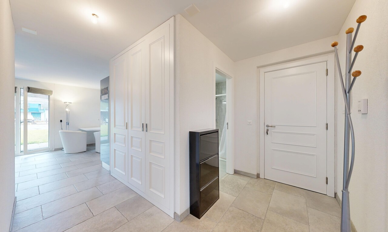 couloir avec inside property, cloison sèche, drywall, sol en carrelage, et tile floor