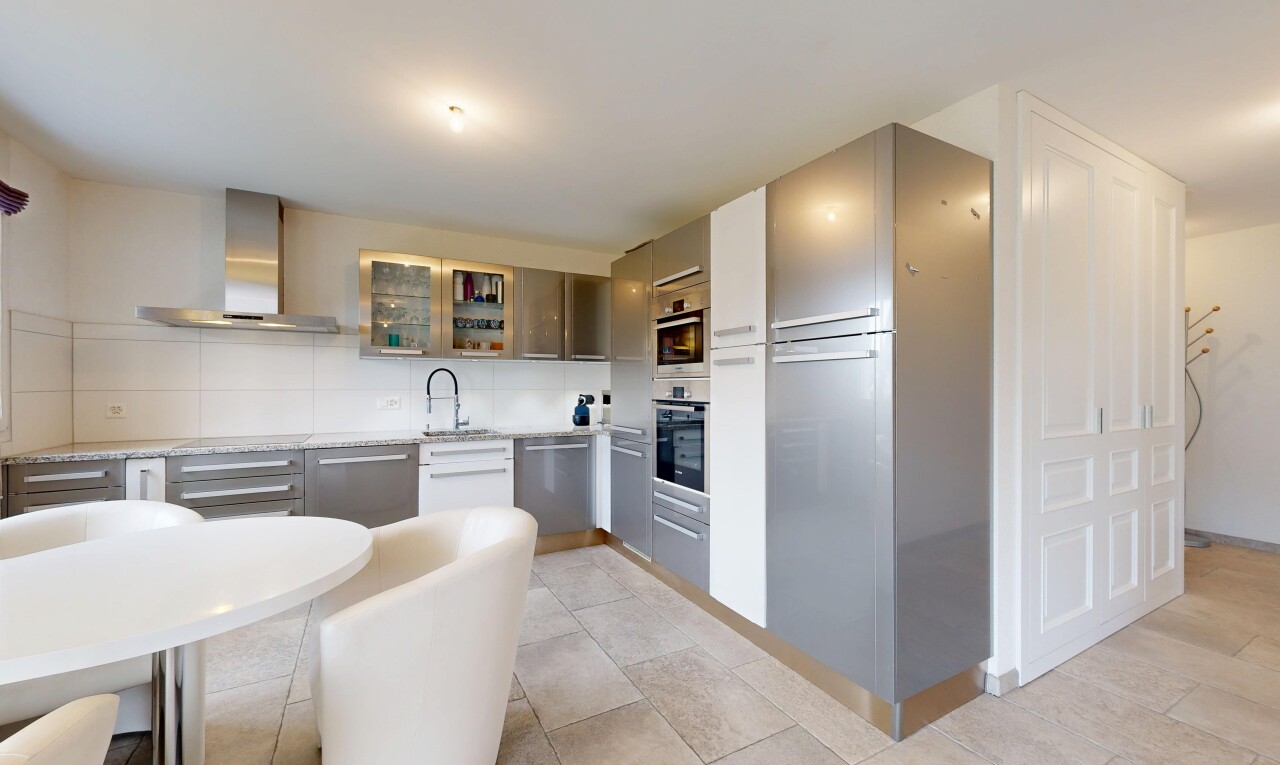 cuisine avec hotte, armoires avec insert en verre, dosseret, backsplash, et inside property