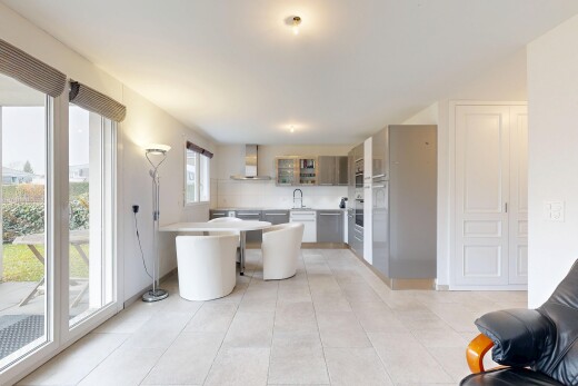 kitchen with light countertops, wall chimney exhaust hood, light tile patterned flooring, a peninsula, and dishwasher