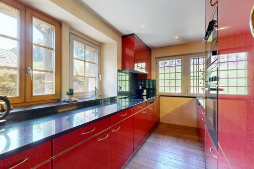 cuisine avec dark countertops, wood finish floor, sol en finition bois, four, et stone countertops