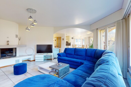 wohnzimmer mit fliesenboden, natürliches licht, fernseher, und gewölbte gehwege