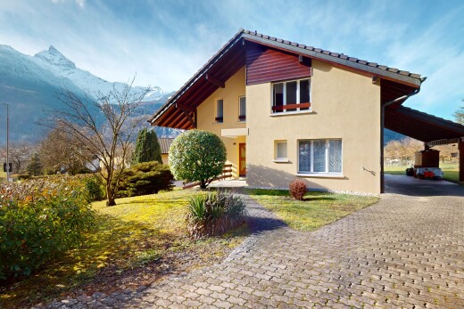 außenansicht mit carport angeschlossen und blick auf die berge