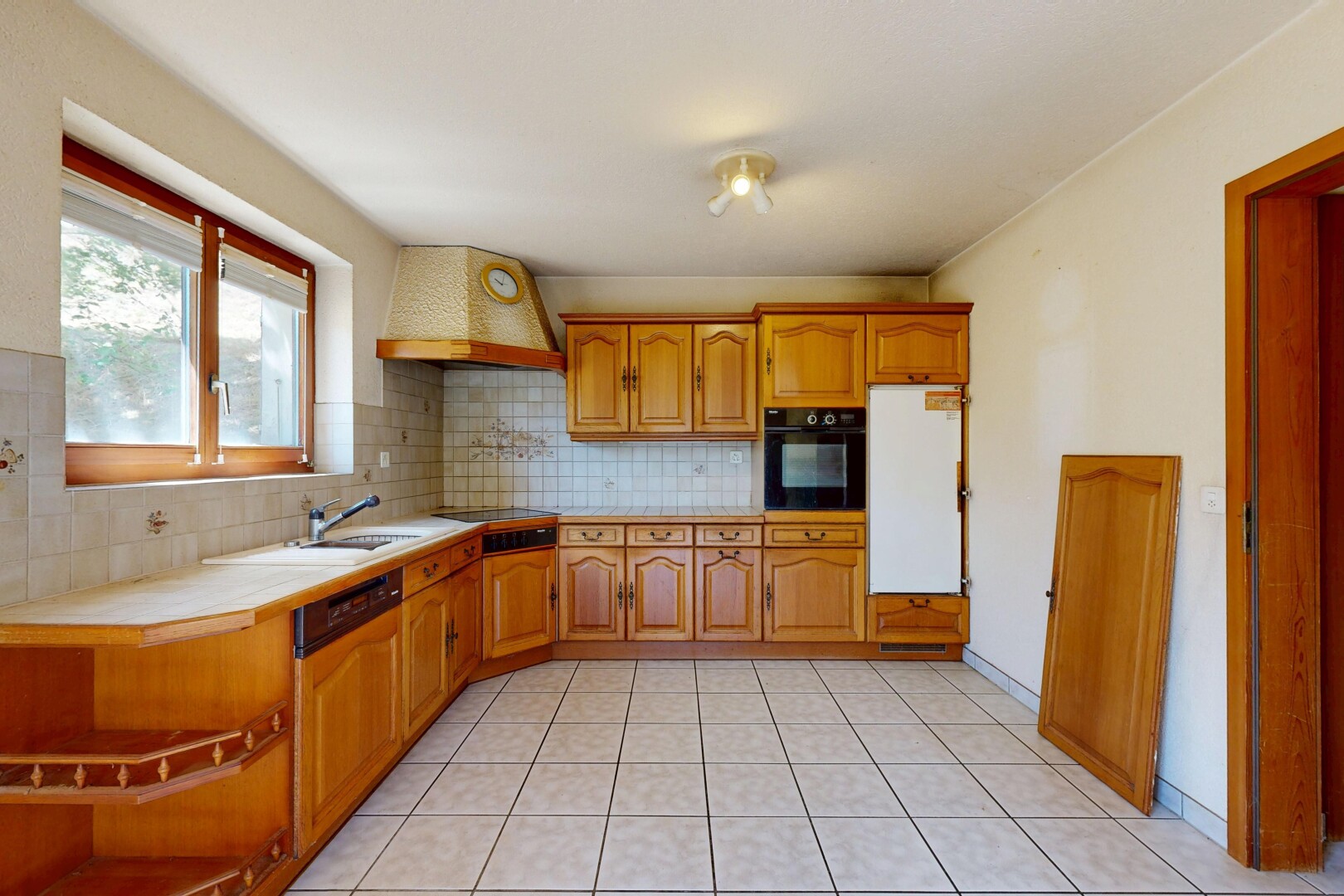 cuisine avec plans de travail en carrelage, tile countertops, light countertops, four, et light floor