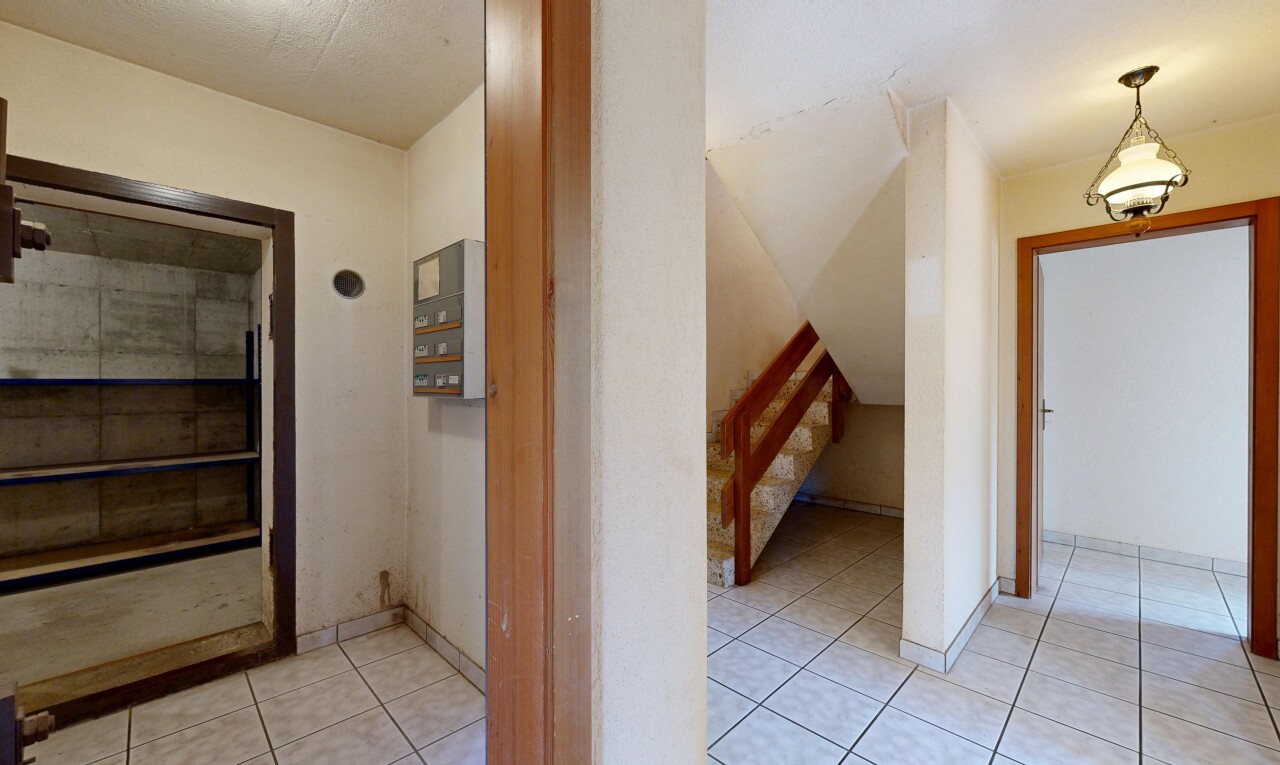 couloir avec cloison sèche, drywall, sol en carrelage, tile floor, et inside property