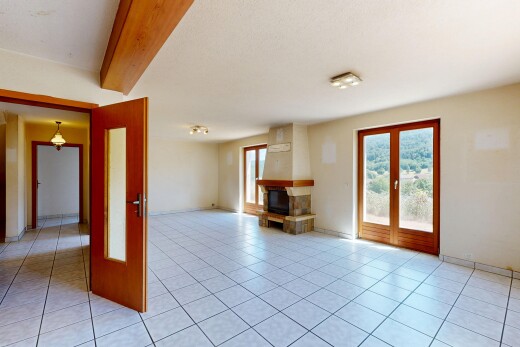 empty room with beam ceiling and light tile patterned floors
