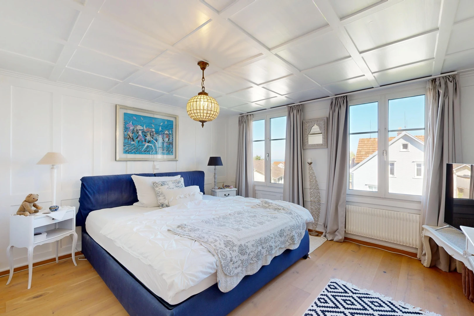 room with radiator heating unit, coffered ceiling, light wood-type flooring, and pendant lighting