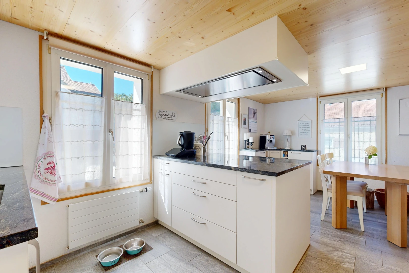 kitchen featuring radiator heating unit, wooden ceiling, white cabinets, access to outside, and a peninsula