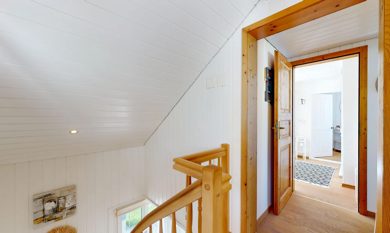 corridor with wooden walls, an upstairs landing, light wood-style floors, recessed lighting, and a vaulted wooden ceiling
