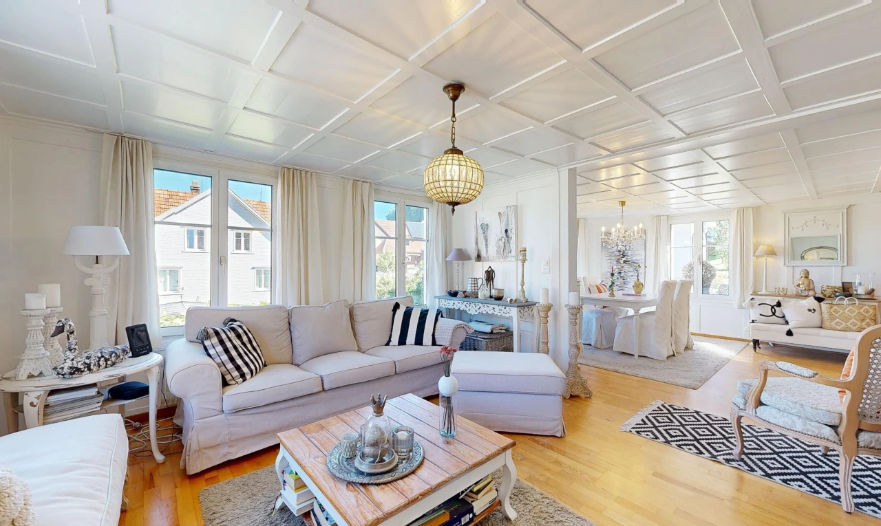 living area with coffered ceiling, healthy amount of natural light, and light wood finished floors