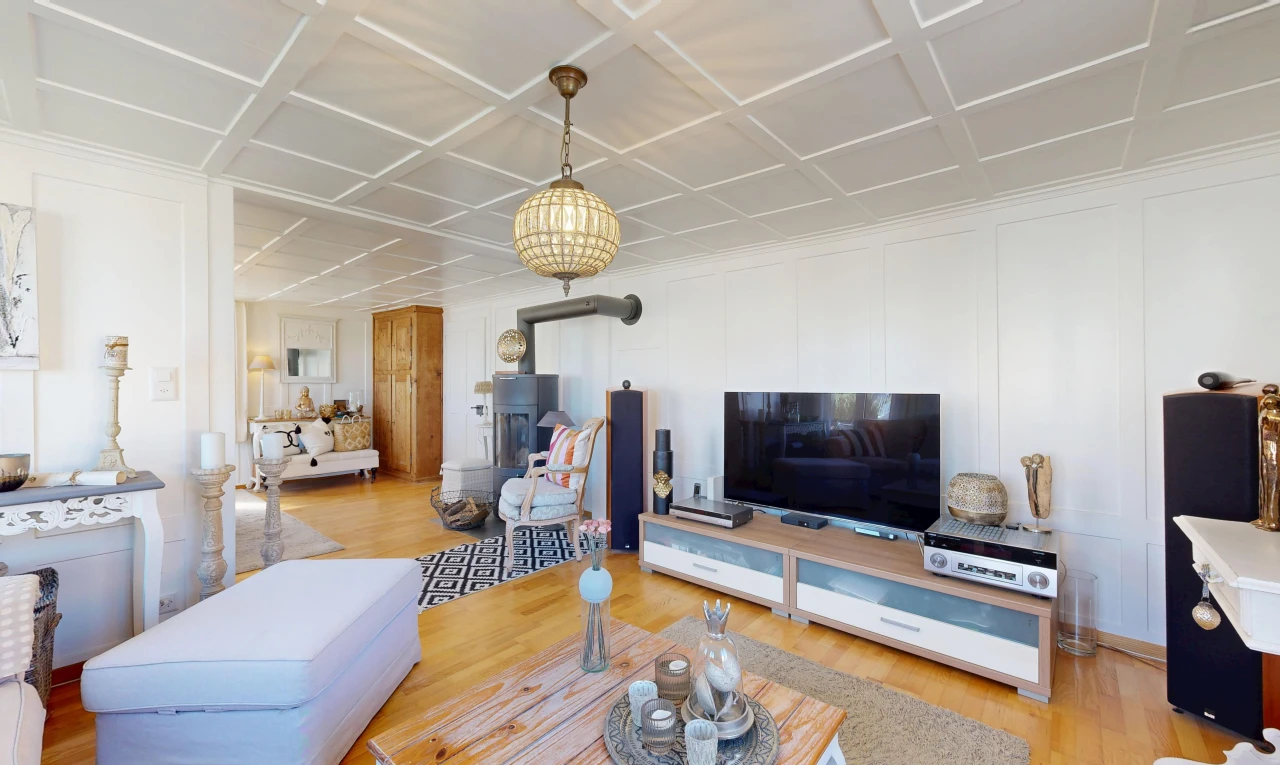 living room with a decorative wall, light wood-style flooring, and coffered ceiling