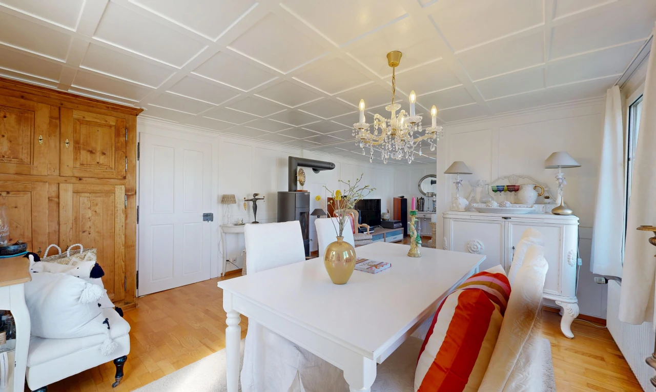 dining area with a decorative wall, light wood-type flooring, coffered ceiling, and suspended lighting