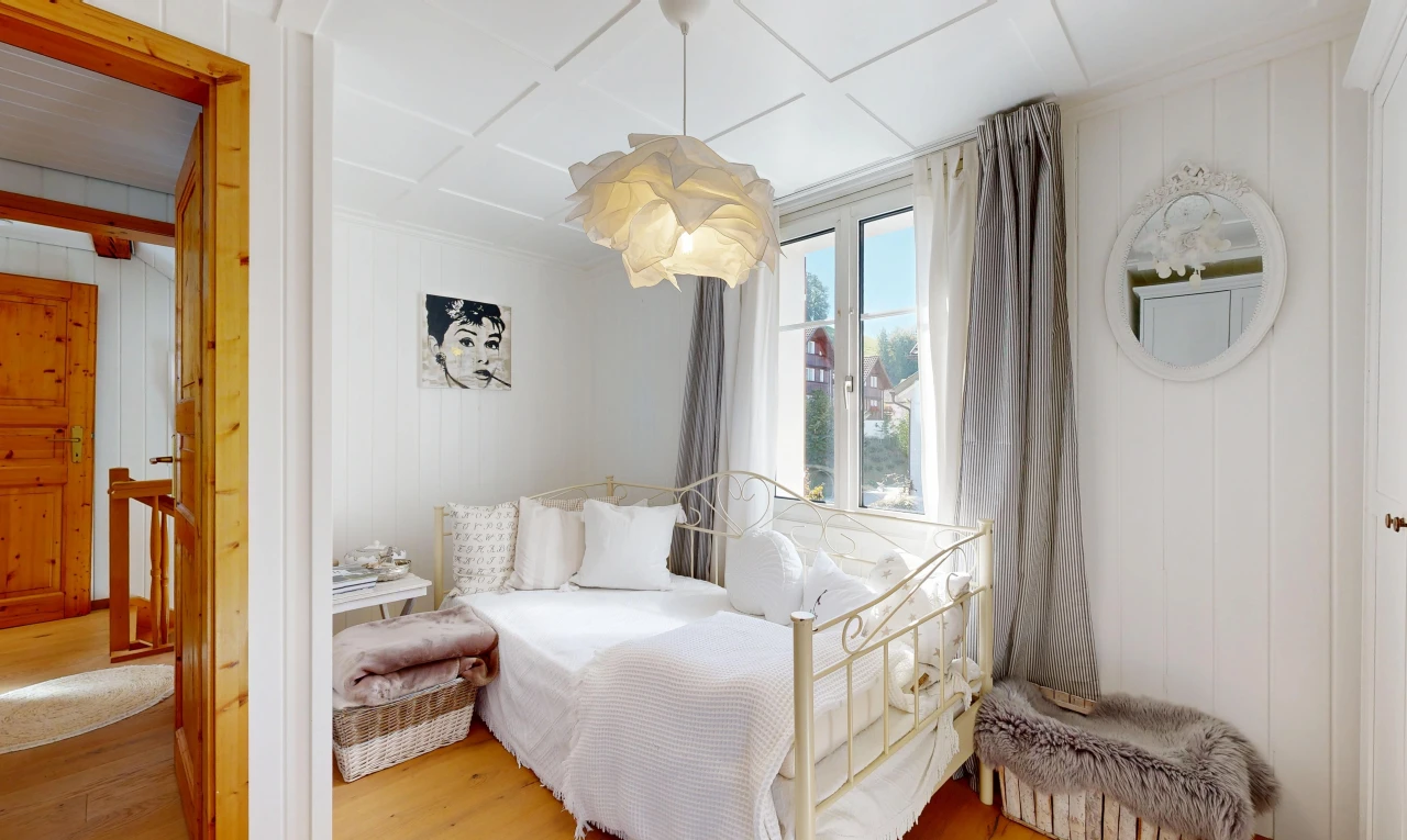 room featuring light wood-style floors, decorative light fixtures, and wooden walls