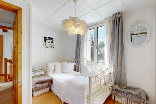 room featuring light wood-style floors, decorative light fixtures, and wooden walls